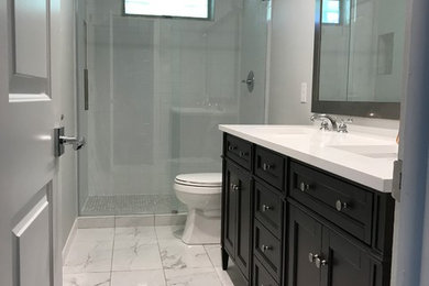 Design ideas for a mid-sized modern kids bathroom in Dallas with an alcove shower, a two-piece toilet, white tile, ceramic tile, multi-coloured walls, porcelain floors, an undermount sink, quartzite benchtops, multi-coloured floor and a hinged shower door.