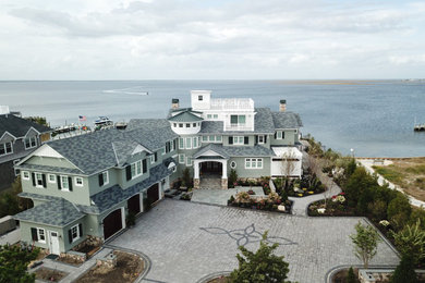 Example of a huge beach style green two-story wood exterior home design in New York with a tile roof