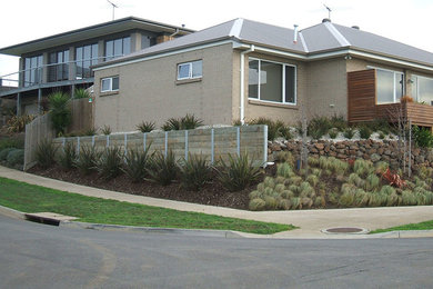 Design ideas for a modern front yard garden in Melbourne with a retaining wall.