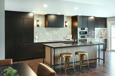 Example of a mid-sized trendy single-wall brown floor open concept kitchen design in Toronto with an undermount sink, beaded inset cabinets, black cabinets, white backsplash, porcelain backsplash, paneled appliances and an island