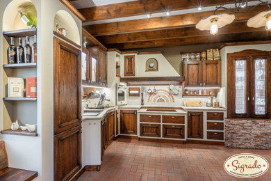 Offene, Mittelgroße Mediterrane Küche ohne Insel in L-Form mit Einbauwaschbecken, Kassettenfronten, dunklen Holzschränken, Arbeitsplatte aus Fliesen, Küchenrückwand in Beige, Rückwand aus Mosaikfliesen, weißen Elektrogeräten, rotem Boden und beiger Arbeitsplatte in Leipzig