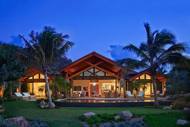 Large tropical one-storey beige exterior in Other with stone veneer.