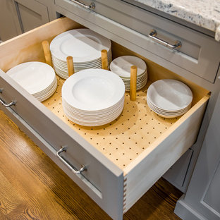 Foto di una cucina ad U tradizionale chiusa e di medie dimensioni con lavello sottopiano, ante in stile shaker, elettrodomestici in acciaio inossidabile, parquet scuro, isola, ante bianche, top in granito, paraspruzzi beige e paraspruzzi in gres porcellanato