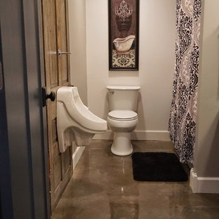 Immagine di una stanza da bagno moderna di medie dimensioni con orinatoio, lavabo rettangolare, nessun'anta, ante grigie, top in legno, vasca ad alcova, pareti grigie e pavimento in cemento