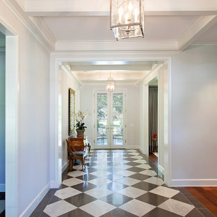 Неиссякаемый источник вдохновения для домашнего уюта: большая узкая прихожая в классическом стиле с белыми стенами, разноцветным полом и полом из винила