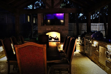 Patio kitchen - mid-sized rustic backyard stamped concrete patio kitchen idea in Dallas