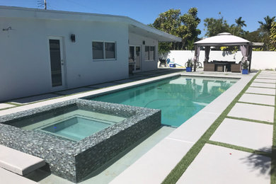 Example of a mid-sized backyard stone patio design in Miami