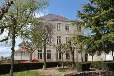 Réalisation d'une façade de maison grise tradition en pierre à deux étages et plus.