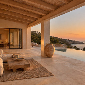 Villa frente al mar · Porche y piscina desbordante al atardecer