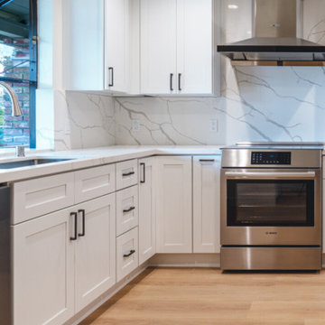 Modern White Shaker Kitchen with Navy Blue Island and Waterfall Quartz Counterto