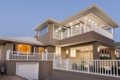 Photo of a mid-sized traditional two-storey concrete grey house exterior in Perth with a gable roof and a metal roof.