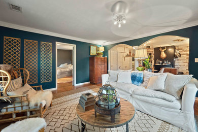 Inspiration for a mid-sized eclectic open concept medium tone wood floor living room remodel in Atlanta with no fireplace and a wall-mounted tv