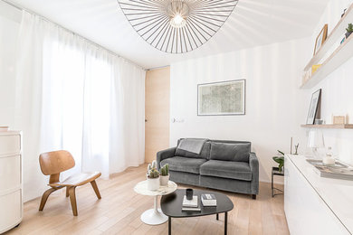 Imagen de salón abierto nórdico de tamaño medio con paredes blancas, suelo de madera clara y suelo beige