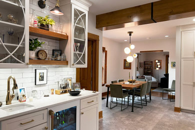 Huge transitional l-shaped vinyl floor and gray floor wet bar photo in Other with an undermount sink, flat-panel cabinets, white cabinets, quartz countertops, white backsplash, subway tile backsplash and white countertops