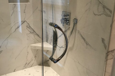 Large transitional master gray tile and porcelain tile porcelain tile and gray floor bathroom photo in Nashville with shaker cabinets, white cabinets, a two-piece toilet, gray walls, a drop-in sink, quartz countertops and a hinged shower door