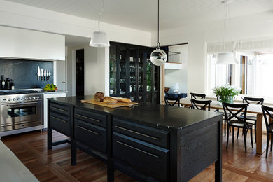Inspiration for a contemporary kitchen in Sydney with flat-panel cabinets, white cabinets, stainless steel appliances, medium hardwood floors and with island.