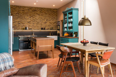 Example of a mid-sized eclectic terra-cotta tile kitchen/dining room combo design in London with pink walls