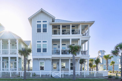Large coastal blue three-story concrete fiberboard and board and batten exterior home idea in Austin with a metal roof and a gray roof