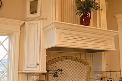 Large elegant u-shaped travertine floor and brown floor enclosed kitchen photo in Other with an undermount sink, raised-panel cabinets, white cabinets, granite countertops, beige backsplash, ceramic backsplash, paneled appliances and an island