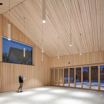 Double-Height Wood Room Opening to a Snowy Courtyard, Berneck Residence