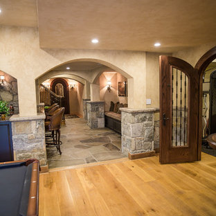 Großes, Offenes Mediterranes Wohnzimmer mit Hausbar, beiger Wandfarbe, hellem Holzboden, Wand-TV und beigem Boden in Washington, D.C.