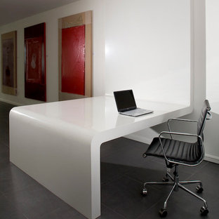 Large modern study in Miami with white walls, travertine flooring and a freestanding desk.
