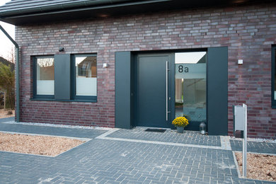Modernes Haus mit Faserzement-Fassade, grauer Fassadenfarbe und Satteldach in Hamburg