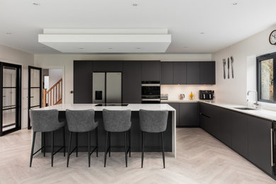 Photo of a large modern l-shaped eat-in kitchen in Other with an undermount sink, flat-panel cabinets, grey cabinets, quartzite benchtops, black appliances, with island, beige floor, white benchtop and recessed.