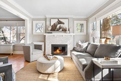 Living room - mid-sized transitional enclosed medium tone wood floor and brown floor living room idea in Minneapolis with a stacked stone fireplace and no tv