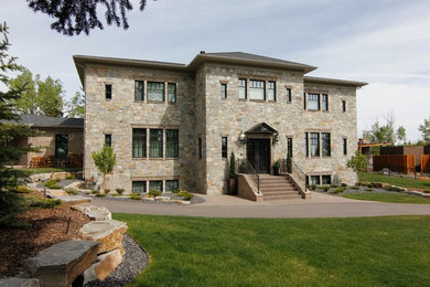 Huge elegant beige two-story stone exterior home photo in Calgary
