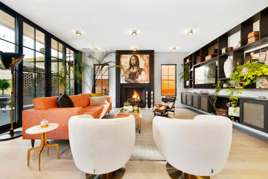 Large modern open plan living room in Denver with white walls, light hardwood flooring, a standard fireplace, a tiled fireplace surround, a built-in media unit and beige floors.