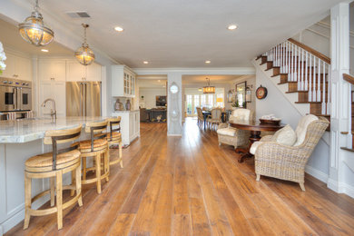 Inspiration for a medium tone wood floor kitchen remodel in Orange County with an undermount sink, shaker cabinets, white cabinets, granite countertops, stainless steel appliances and an island