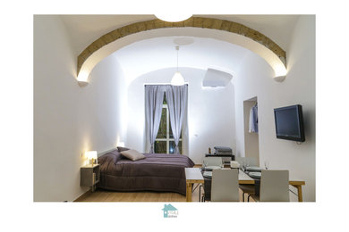 Immagine di un soggiorno minimalista di medie dimensioni e aperto con pareti bianche, pavimento in gres porcellanato, nessun camino, TV a parete e pavimento marrone