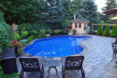 This is an example of a mid-sized traditional partial sun backyard stone water fountain landscape in Toronto.
