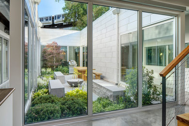 This is an example of a large modern drought-tolerant and partial sun courtyard stone landscaping in Chicago with a fire pit for winter.