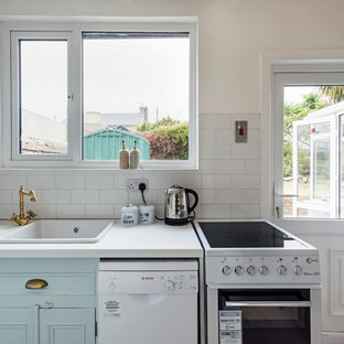 Inspiration pour une petite arrière-cuisine victorienne en U avec un évier encastré, un placard à porte affleurante, des portes de placard turquoises, un plan de travail en bois, une crédence blanche, une crédence en carreau de céramique, un électroménager blanc, sol en stratifié, aucun îlot, un sol gris et un plan de travail blanc.
