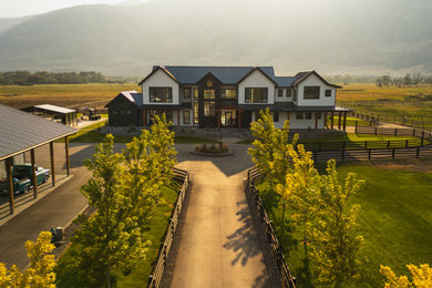 Example of a huge trendy two-story concrete fiberboard and board and batten house exterior design in Vancouver with a butterfly roof, a metal roof and a black roof