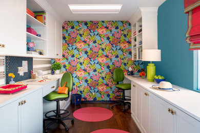Cette photo montre un bureau tendance de taille moyenne et de type studio avec un mur bleu, un sol en bois brun, aucune cheminée et un bureau intégré.