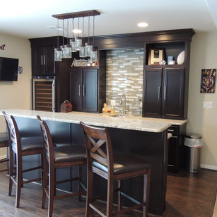 デトロイトの中サイズのトラディショナルスタイルのおしゃれな着席型バー (シェーカースタイル扉のキャビネット、濃色木目調キャビネット、御影石カウンター、ベージュキッチンパネル、ガラスタイルのキッチンパネル、濃色無垢フローリング) の写真