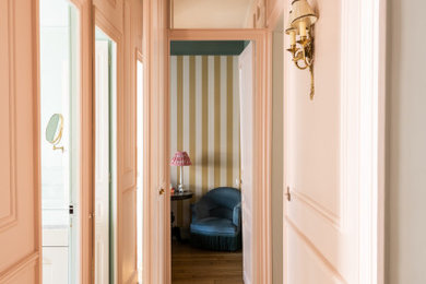 Idées déco pour un couloir classique de taille moyenne avec un mur rose, un sol en bois brun, un sol marron et du papier peint.