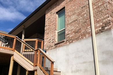 Inspiration for a large contemporary red two-story brick exterior home remodel in Austin with a shingle roof
