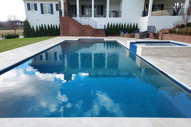 Пример оригинального дизайна: большой прямоугольный бассейн на заднем дворе в классическом стиле с джакузи и покрытием из каменной брусчатки