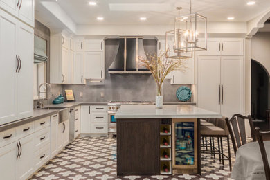 Open concept kitchen - large transitional l-shaped cement tile floor and multicolored floor open concept kitchen idea in Phoenix with a farmhouse sink, shaker cabinets, white cabinets, quartz countertops, gray backsplash, stone slab backsplash, paneled appliances, an island and gray countertops