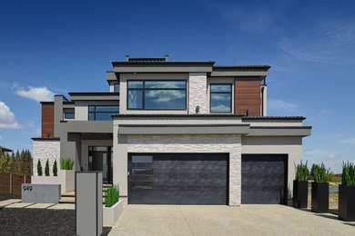 Photo of a large contemporary three-storey stucco multi-coloured house exterior in Edmonton.