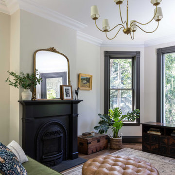 Sitting room with cast-iron fireplace and dark green trim