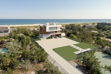 This is an example of a mid-sized contemporary three-storey stucco white house exterior in New York with a flat roof and a mixed roof.