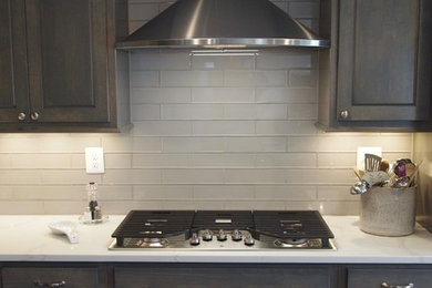 Inspiration for a large transitional l-shaped vinyl floor and brown floor open concept kitchen remodel in Baltimore with a single-bowl sink, raised-panel cabinets, gray cabinets, quartz countertops, gray backsplash, glass tile backsplash, stainless steel appliances and an island