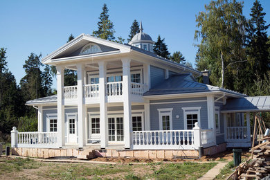 Foto de fachada de casa gris clásica de dos plantas con revestimiento de madera, tejado a dos aguas y tejado de metal