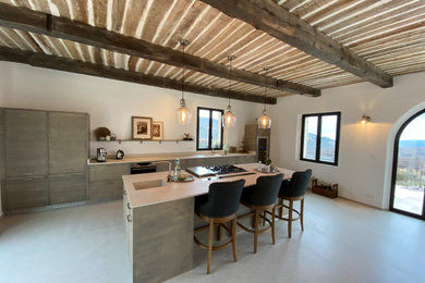 Example of a minimalist galley kitchen design with beige backsplash, an island and beige countertops