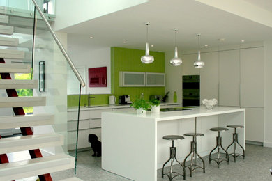 Large contemporary open plan kitchen in Other with flat-panel cabinets, white cabinets, solid surface benchtops, with island, ceramic splashback and porcelain floors.